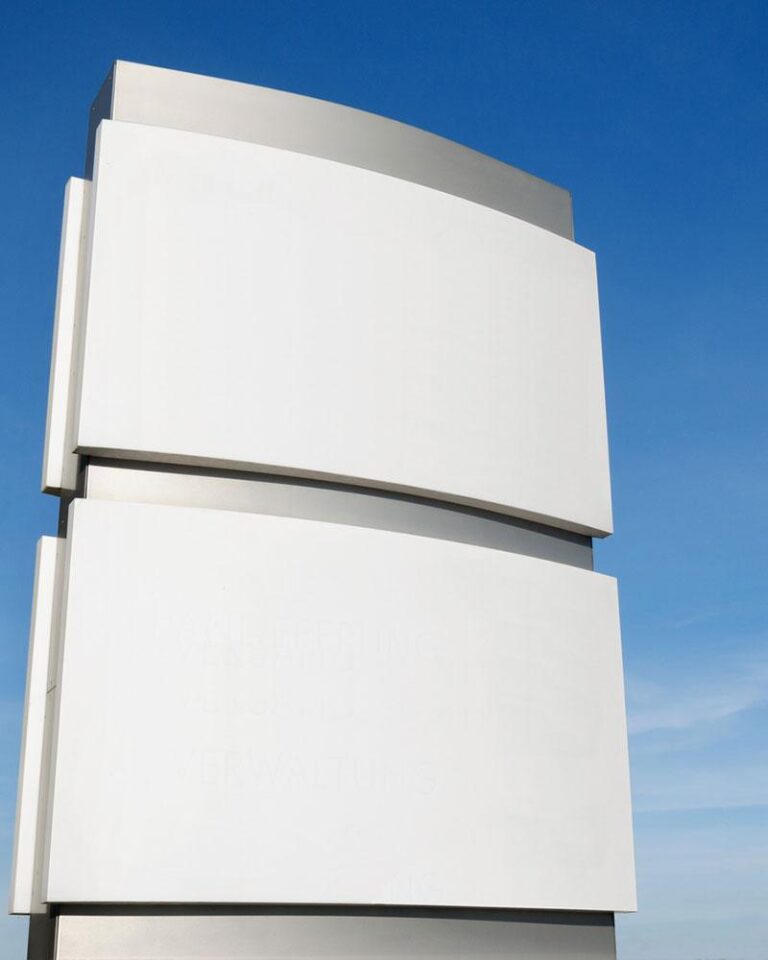 Unbeschrifteter Pylon zur visuellen Kommunikation vor einem Eingang.