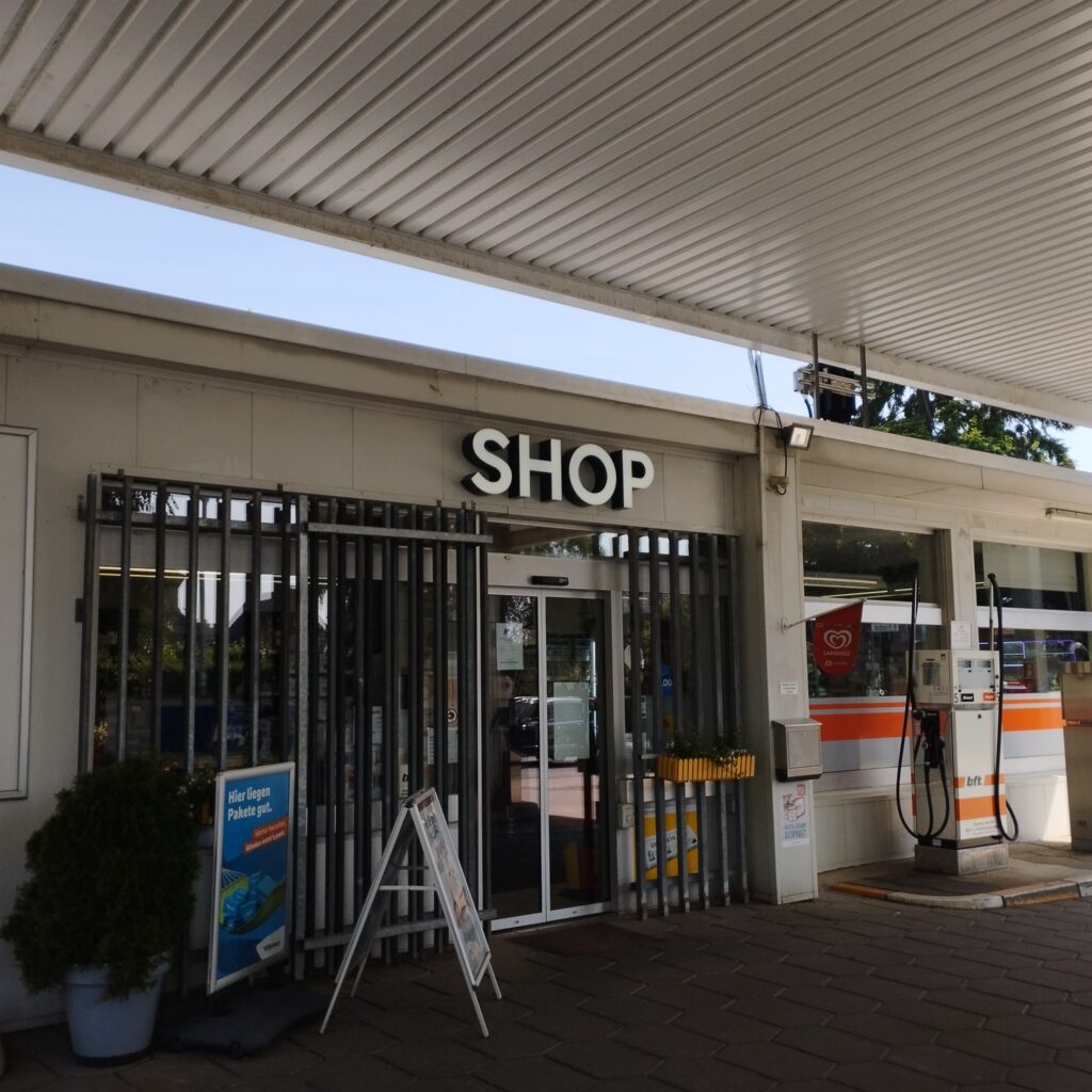 Exterior view of the BFT petrol station in Hünxe with profile letters SHOP above the entrance area.