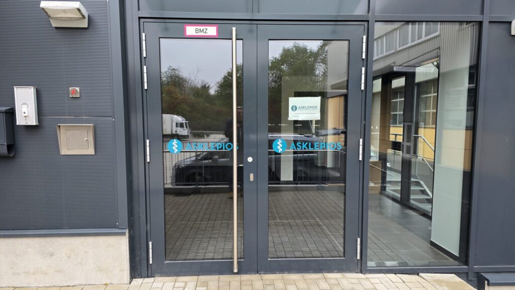 Torbeschriftung mit Asklepios-Logo auf dunklem Hintergrund