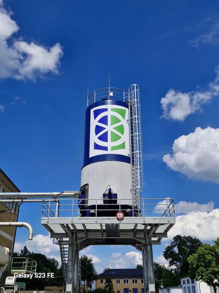Industrietank mit Logo-Beschriftung unter blauem Himmel