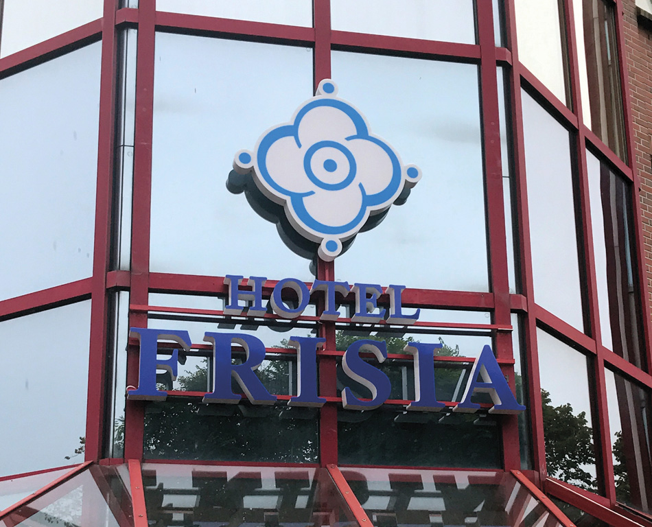 Moderne Außenbeschilderung eines Hotels mit LED-Technik und Logo.