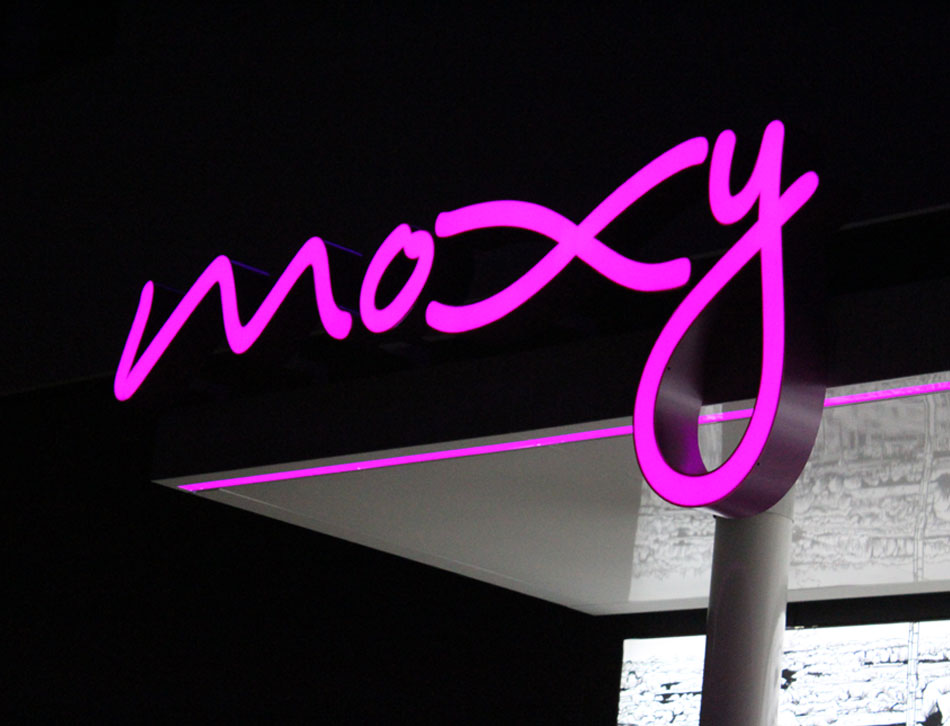 Pink beleuchteter LED Hotelschriftzug am Vordach als Beispiel für moderne Leuchtreklame.